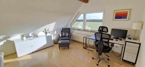 a room with a desk with a computer and two chairs at Schöne Wohnung mit Blick ins Grüne Messenah Exhibition apartment in Sehnde