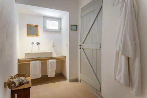 a bathroom with a sink and a mirror and a door at Masseria Palombara Relais & SPA - Adults only in Manduria