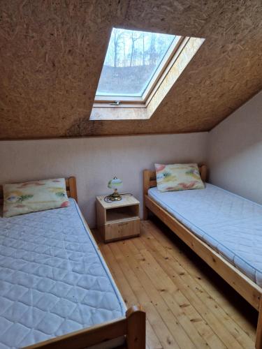 two twin beds in a room with a window at Casa Jan Bonca in Lorău