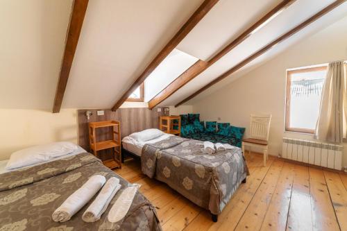 a attic bedroom with two beds and a window at Snow Time Cottage in Gudauri