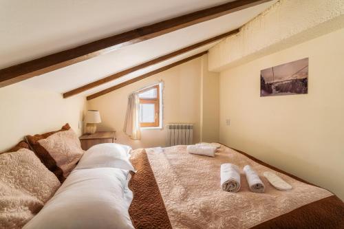 a bedroom with a large bed with towels on it at Snow Time Cottage in Gudauri