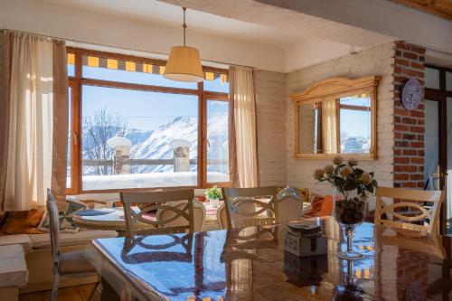 a living room with a table and a view of a mountain at Snow Time Cottage in Gudauri