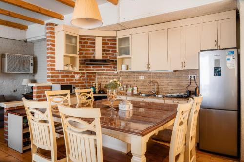 a kitchen with a wooden table and a refrigerator at Snow Time Cottage in Gudauri