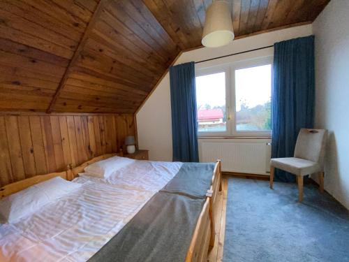ein Schlafzimmer mit einem Bett, einem Stuhl und einem Fenster in der Unterkunft Kargulena in Sztutowo