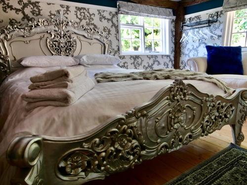a bedroom with a bed with a gold bed frame at Captivating 9-Bed House Hot Tub Near Cambridge in Saffron Walden