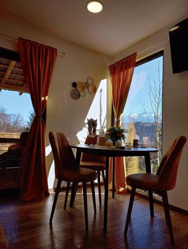 a dining room with a table and chairs and a window at Touch the Sky in Moieciu de Jos