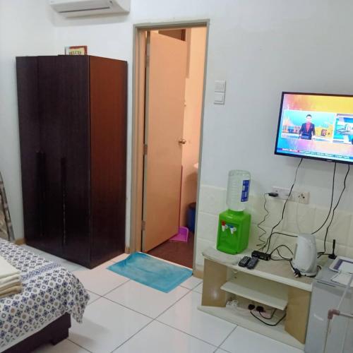 een slaapkamer met een bed en een tv aan de muur bij JM in Shah Alam