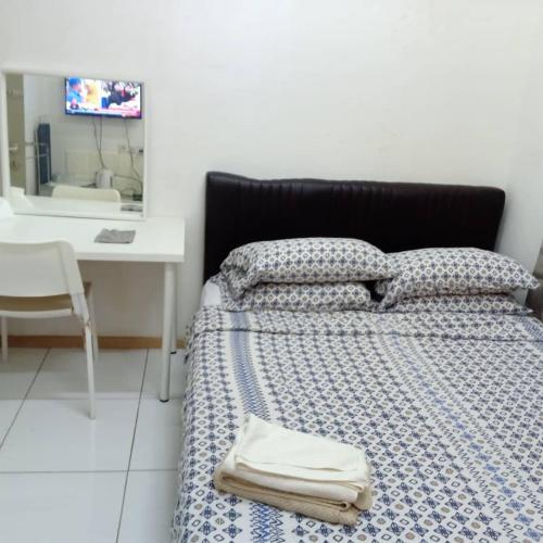 een slaapkamer met een bed, een bureau en een wastafel bij JM in Shah Alam
