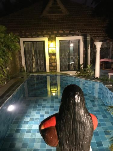 a statue of a penguin in a pool at night at Marari Dreamz Homestay in Mararikulam