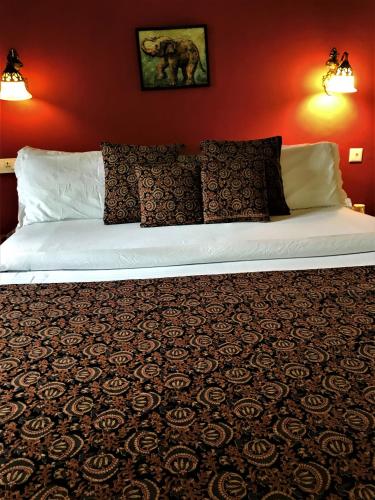 a white bed in a room with a red wall at Marari Dreamz Homestay in Mararikulam