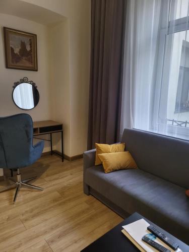 ein Wohnzimmer mit einem Sofa, einem Stuhl und einem Fenster in der Unterkunft AMBER APARTAMENt #12 in Krakau