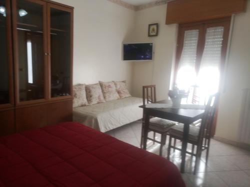 ein Wohnzimmer mit einem Sofa und einem Tisch mit Stühlen in der Unterkunft Antico Portale - Host Roberto in Regalbuto