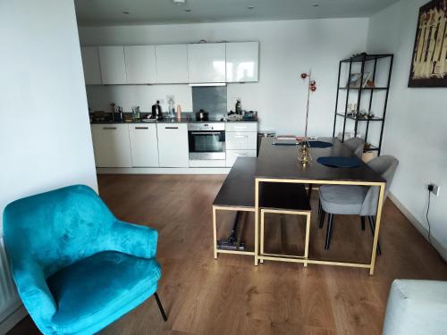 sala de estar con silla azul y mesa en Cosy and spacious apartment in Forest Hill en Forest Hill