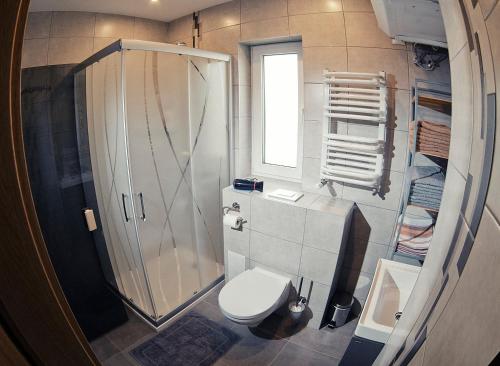 a small bathroom with a shower and a toilet at Przystanek Tykocin - domki gościnne w sercu Podlasia in Tykocin
