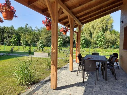 a wooden pergola with a table and chairs on a patio at Przystanek Tykocin - domki gościnne w sercu Podlasia in Tykocin