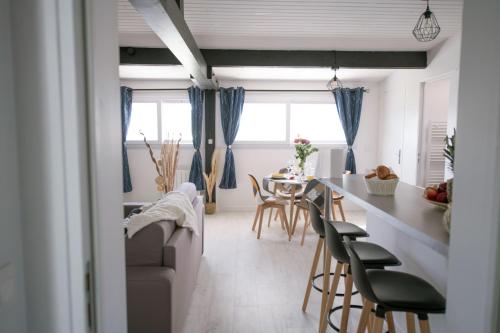 uma cozinha e sala de estar com mesa e cadeiras em Le Charmant Pontault Combault em Pontault-Combault