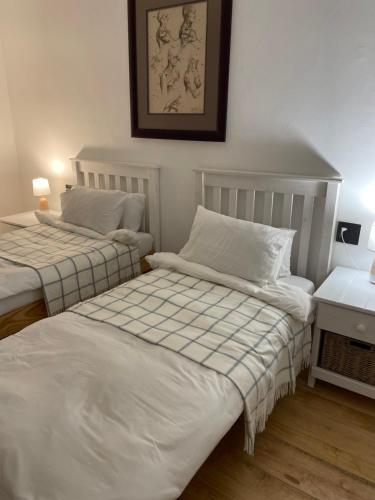 2 camas individuales en un dormitorio con una foto en la pared en Swakopmund private room in family home, en Swakopmund