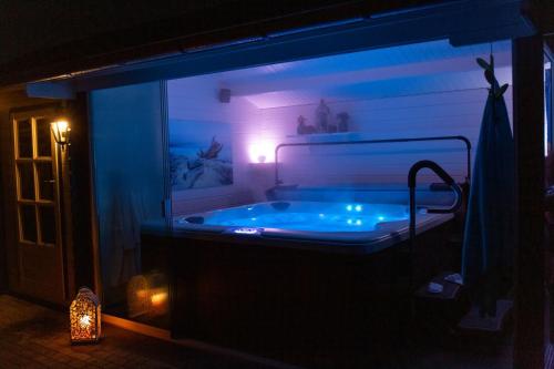 Alana Care Bed & Breakfast في Tonden: حوض استحمام مضاء في الغرفة في الليل