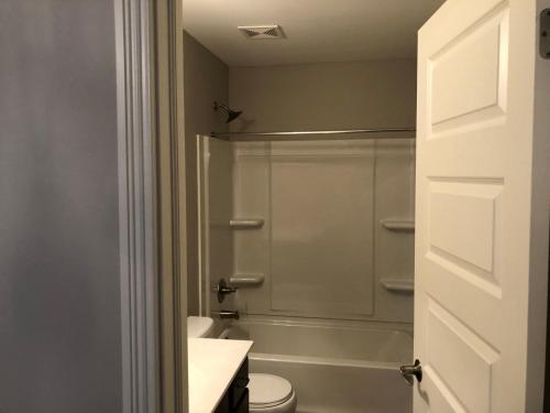 uma casa de banho com um chuveiro, um WC e um lavatório. em Lakefront view private bedroom and bathroom with kitchen em McCordsville
