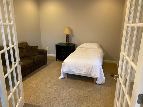 uma sala de estar com uma cama e um sofá em Lakefront view private bedroom and bathroom with kitchen em McCordsville