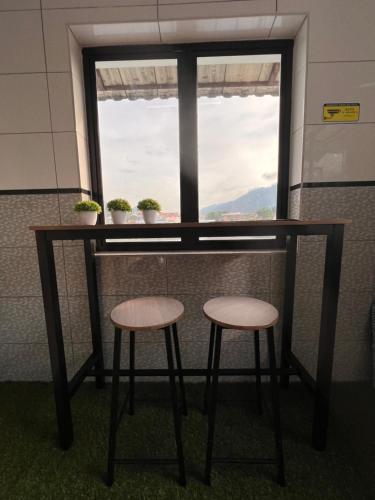 a table and two stools in front of a window at Room2#IG theme Bargainous#Shared Bathroom#4pax#2min Kek Lok Si in Ayer Itam