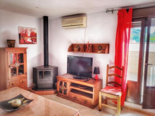sala de estar con TV y estufa de leña en Apartamento La alberca 1, en Aracena