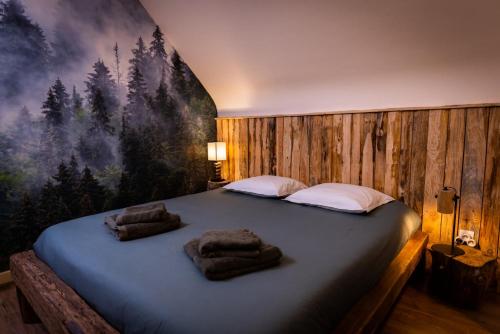 um quarto com uma cama grande e toalhas em Maison de Rêve en Alsace - Chez Maïdala 3 étoiles em Houssen