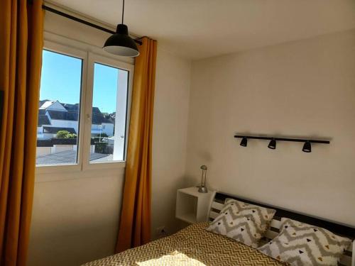 une chambre avec un lit et une fenêtre dans l'établissement Superbe appartement en plein centre de Carnac, à Carnac