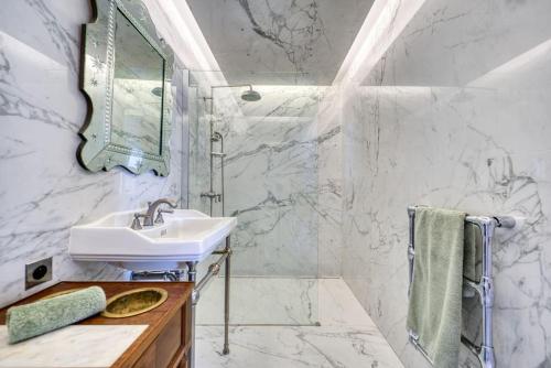 een witte badkamer met een wastafel en een spiegel bij Le 9 bis, Idéal pour un couple. in Le Bois-Plage-en-Ré