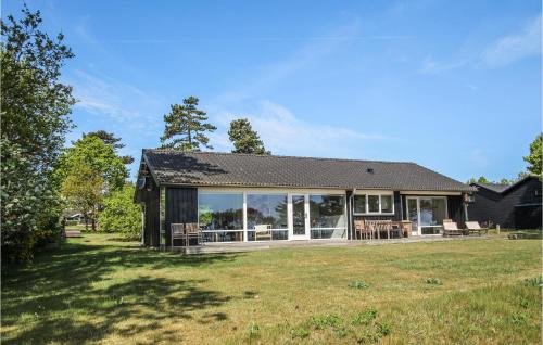 a house with a large window on a yard at Stunning Home In Samsø With Sauna in Ballen