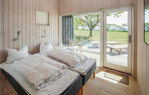 Bett in einem Zimmer mit Glasschiebetür in der Unterkunft Stunning Home In Sams With Sauna in Ballen