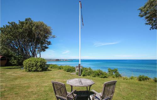 a table and two chairs sitting next to the ocean at 3 Bedroom Gorgeous Home In Samsø in Ballen
