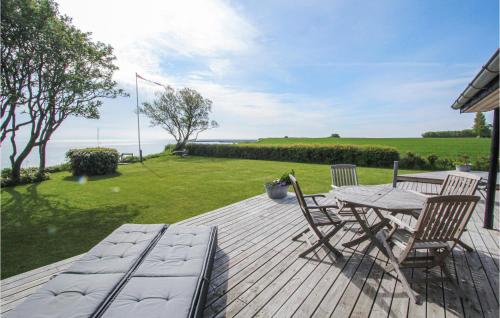 a wooden deck with a table and chairs on it at 3 Bedroom Gorgeous Home In Samsø in Ballen