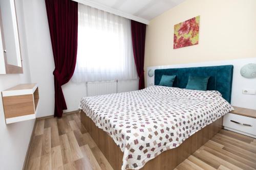 a small bedroom with a bed and a window at Dodona ApartHotel in Prishtina in Pristina