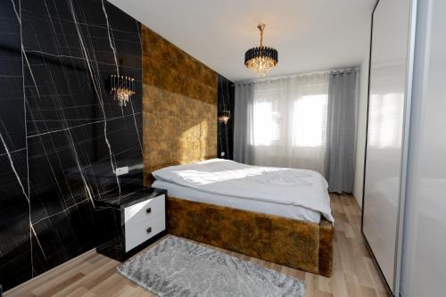 Dodona ApartHotel in Prishtina في بريشتيني: غرفة نوم بسرير وجدار من البلاط