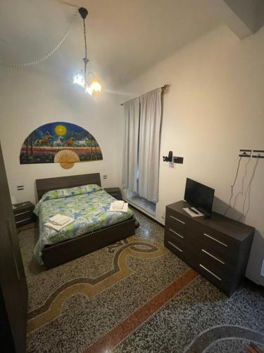 a bedroom with a bed and a desk with a laptop at Affittacamere Fuorigrotta in Genoa