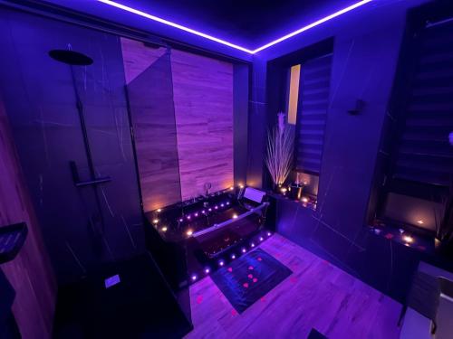 a purple bathroom with a tub with lights in it at Aux Secrets De Lora, Chambre de charme VIP in Verviers