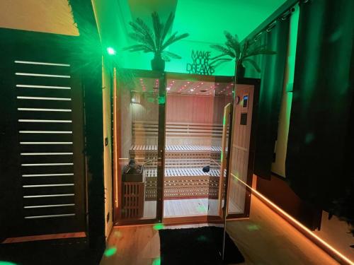 a room with a shower with green lights at Aux Secrets De Lora, Chambre de charme VIP in Verviers