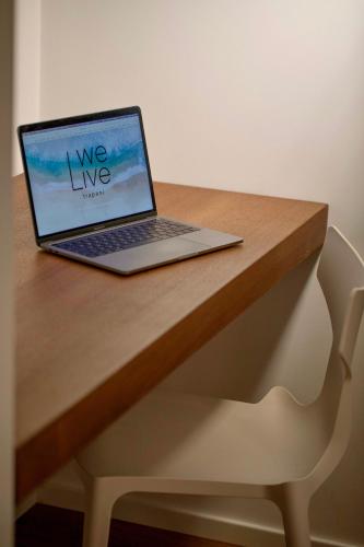 a laptop computer sitting on top of a wooden desk at WeLive Trapani - luxury apartments in Trapani