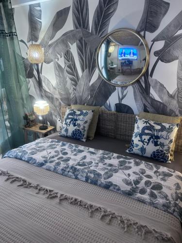 une chambre avec un lit avec un miroir au mur dans l'établissement LE BALI, à La Grande Motte