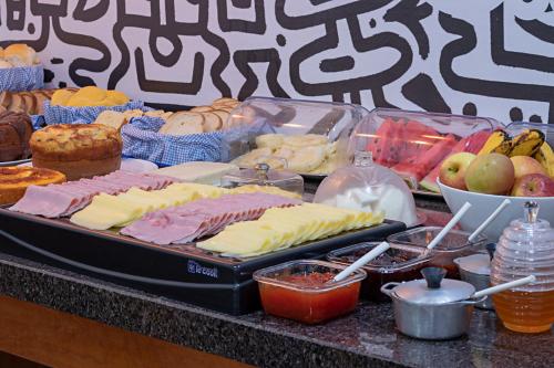 a buffet of cheese and other foods on a table at Pousada Caminho das Aguas in Brotas