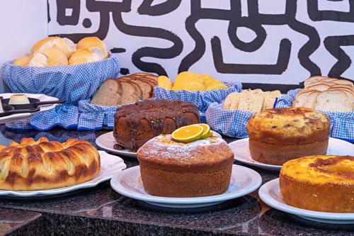 a bunch of different types of cakes and pastries on plates at Pousada Caminho das Aguas in Brotas