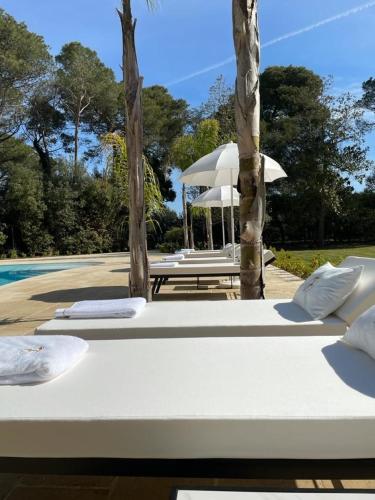 a group of lounge chairs next to a pool at Villa Di Noi in Arnesano