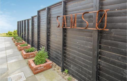 a black fence with a metal sign on it at Nice Home In Samsø With House Sea View in Ballen