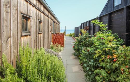 a garden path next to a building with plants at Nice Home In Samsø With House Sea View in Ballen