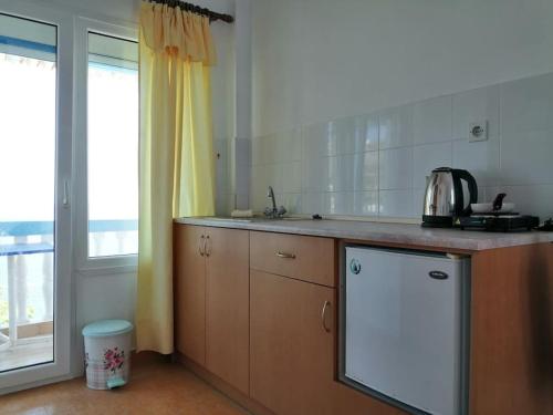 a kitchen with a counter and a sink and a window at RODON PIGANOUSA STUDIO in Spilia Leros in Panteli