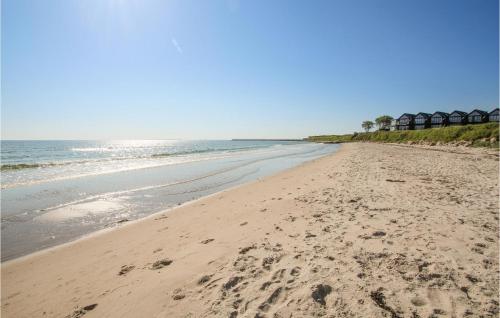a beach with footprints in the sand and the ocean at Cozy Home In Samsø With Wifi in Ballen