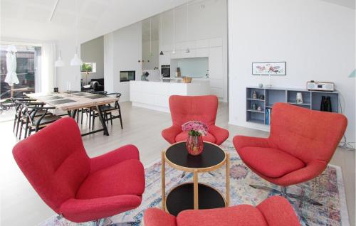 a living room with red chairs and a table at Cozy Home In Samsø With Wifi in Ballen