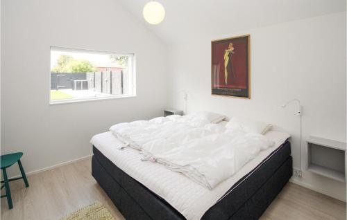 a large bed in a white room with a window at Cozy Home In Samsø With Wifi in Ballen