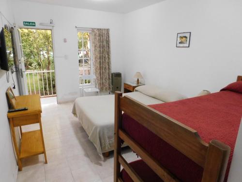 una camera con letto e finestra con balcone di Hostería Teuly a Puerto Madryn